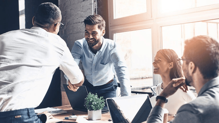 Team shaking hands in a bright office